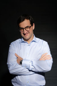 Mid adult man standing against black background