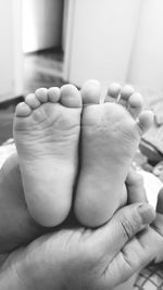 Cropped hands holding baby feet