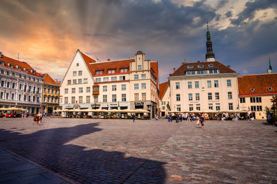 People walking on street against buildings in city