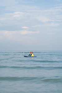 Men on boat in sea against sky