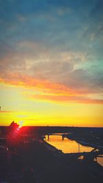 Scenic view of sea against dramatic sky during sunset