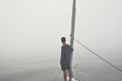 Rear view of man standing on boat