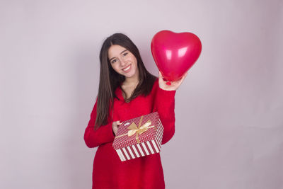 Portrait of a smiling young woman against white background