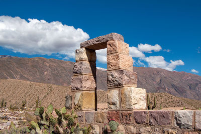 Built structure on mountain against cloudy sky