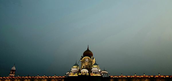 Illuminated buildings in city against sky