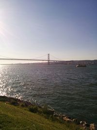 View of suspension bridge over sea against clear sky