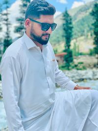 Portrait of young man wearing sunglasses standing outdoors