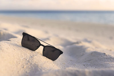 Close-up of sunglasses on beach