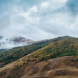 Scenic view of mountains against cloudy sky