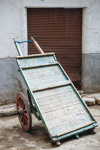 Push cart on sidewalk against wall