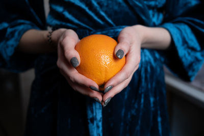 Midsection of woman holding oranges