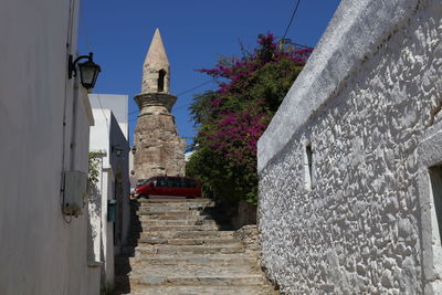 Walkway amidst buildings against sky