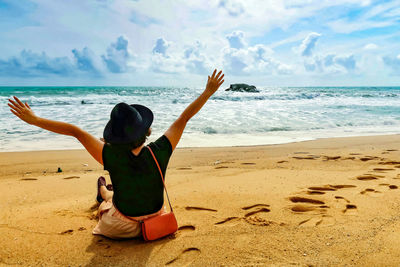 Rear view of man sitting on beach