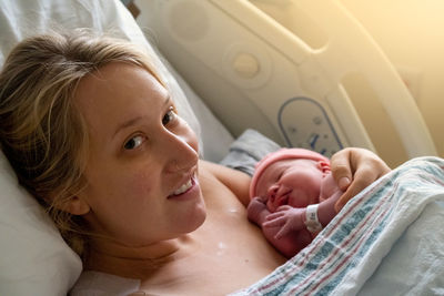 Close-up of cute baby boy lying on bed at home