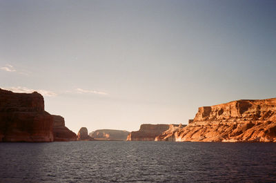 Scenic view of water and sky and the rocky red sandstone cliffs of lake powell, shot on film