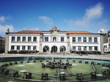 Fountain in front of building against sky