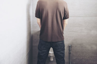 Rear view of man standing against wall