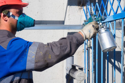 Side view of man standing in factory