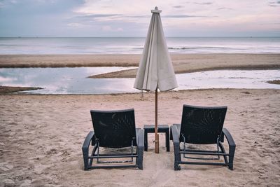 Beach chairs and an umbrella in the evening