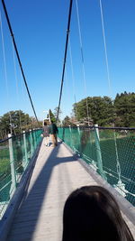 Shadow on bridge over sea against clear blue sky