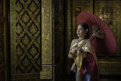 Woman standing against curtain