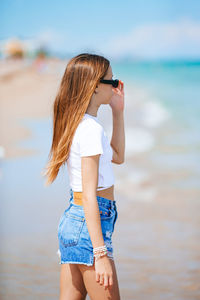 Side view of woman standing at beach