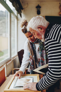 Senior man and woman examining painting at home