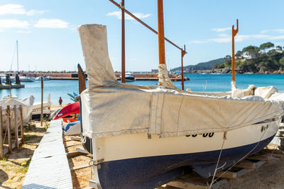 Sailboats moored on beach against sky