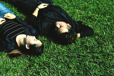 High angle view of friends sleeping on grassy field