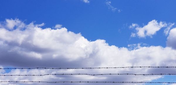 Low angle view of power lines against sky