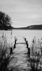 Wooden pier on lake against sky