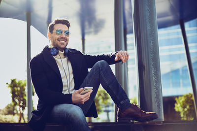 Young man sitting in front of window