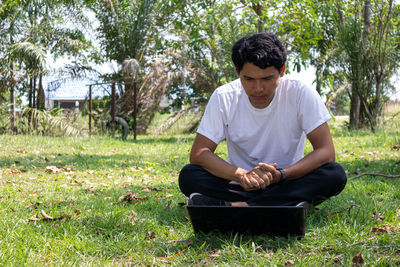 Young man sitting on field