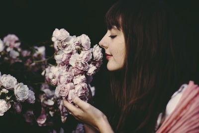 Close-up of young woman smelling flowers