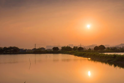 Scenic view of lake against orange sky