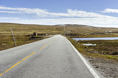 Road leading towards landscape against sky