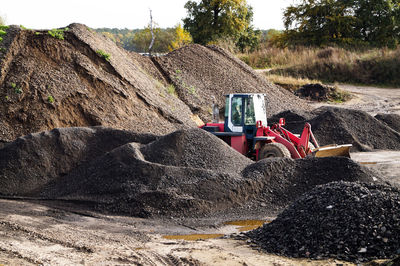 Tractor amidst sand heaps in coal mine