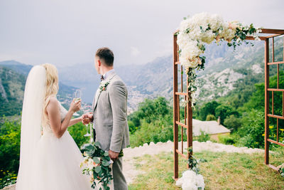 Rear view of couple kissing against plants