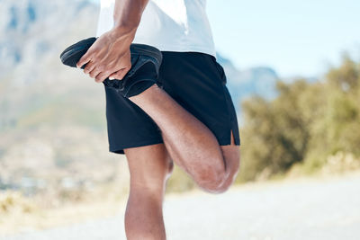 Low section of man exercising on field