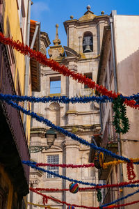 Low angle view of lanterns hanging by building against sky