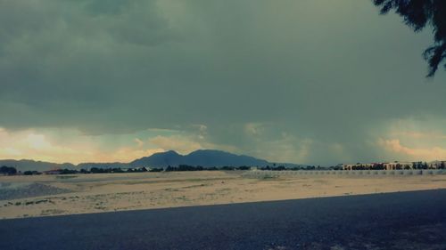 Scenic view of beach against sky at sunset