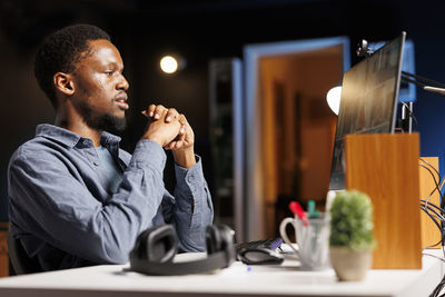 Young man using mobile phone while sitting at restaurant