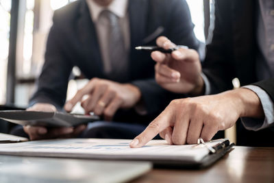 Midsection of man holding hands on table