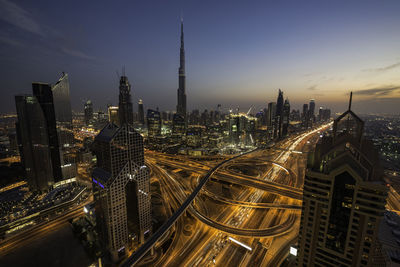 High angle view of illuminated cityscape against sky at dusk