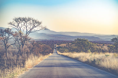 Empty road on landscape against clear sky