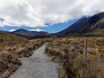 Road leading towards mountains against sky