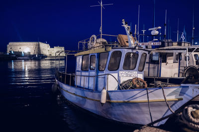 Boats moored in harbor at night