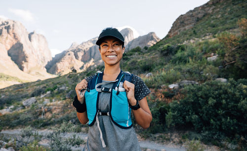 Happy woman standing against mountains