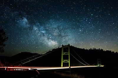 Low angle view of illuminated bridge against sky at night