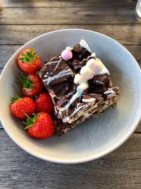 High angle view of strawberries and rockie road chocolate cake on table